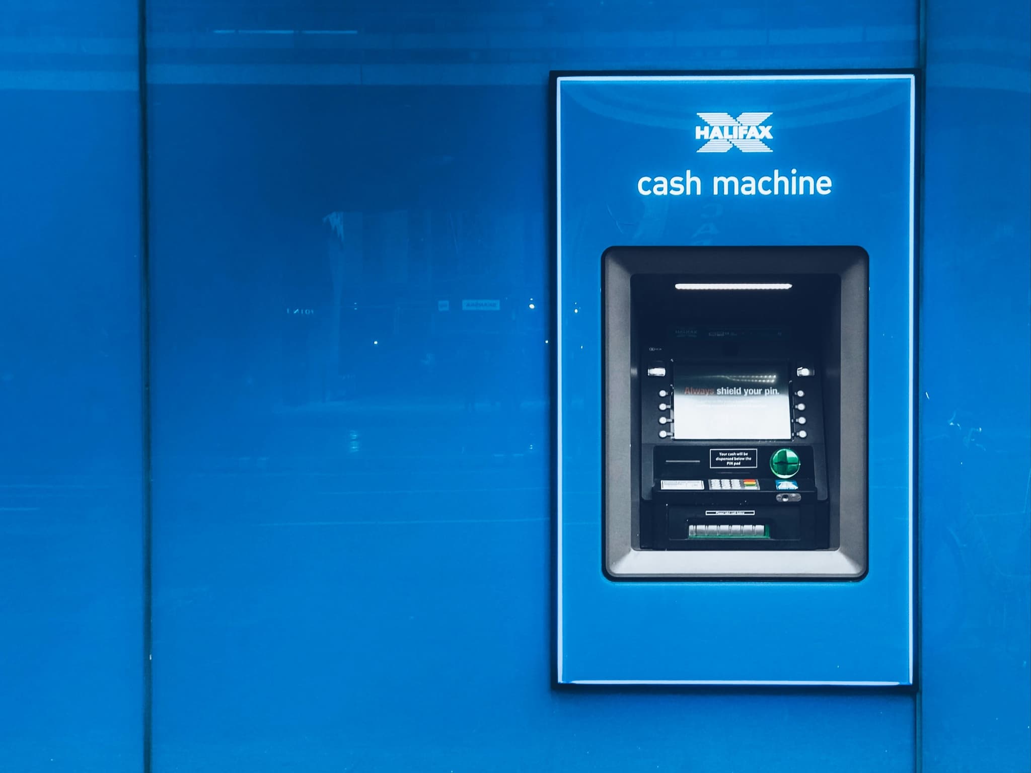 A cash machine set into a blue wall, marked simply 'cash machine'
