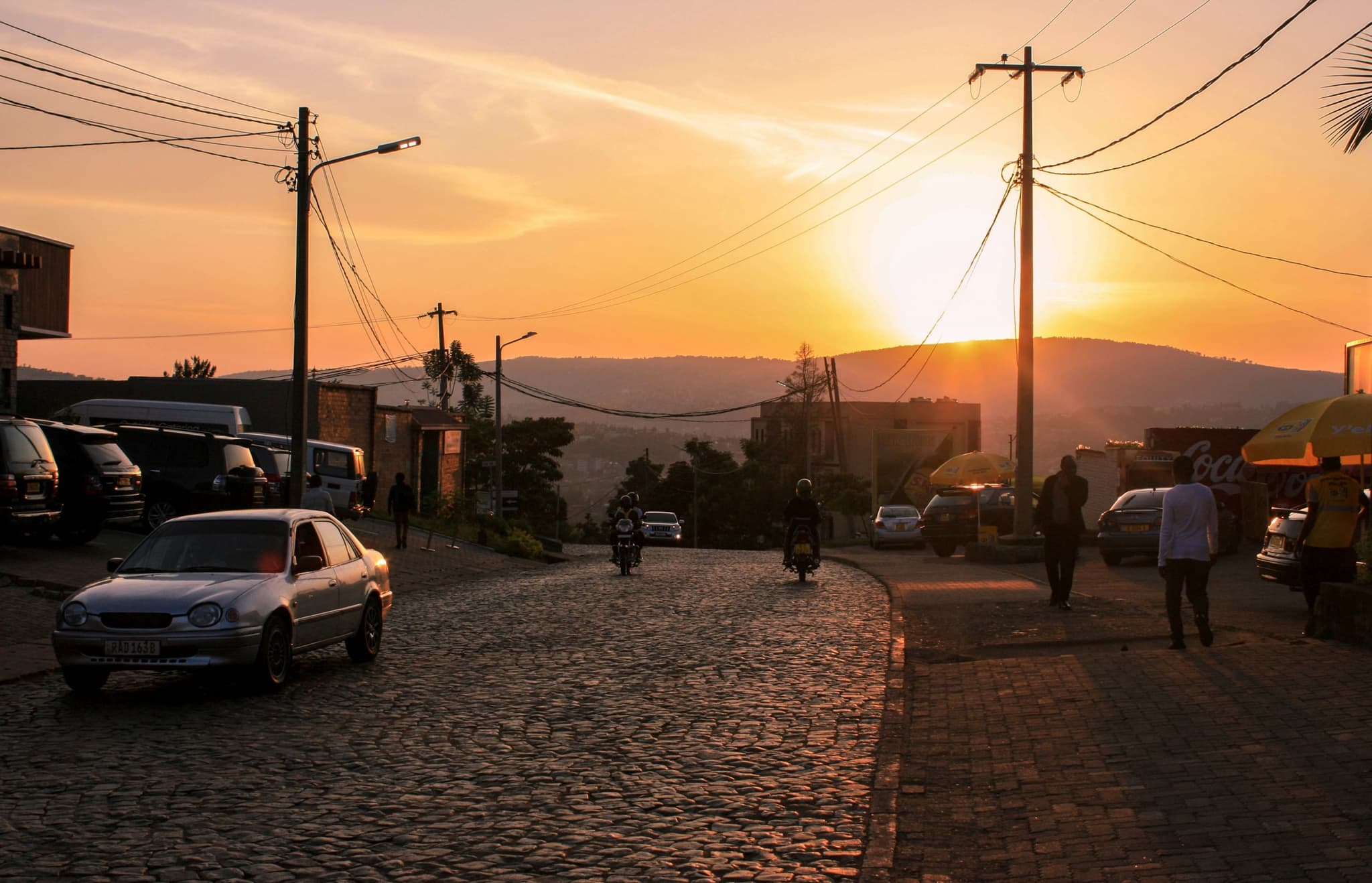 A town street at sunset, power lines strung overhead