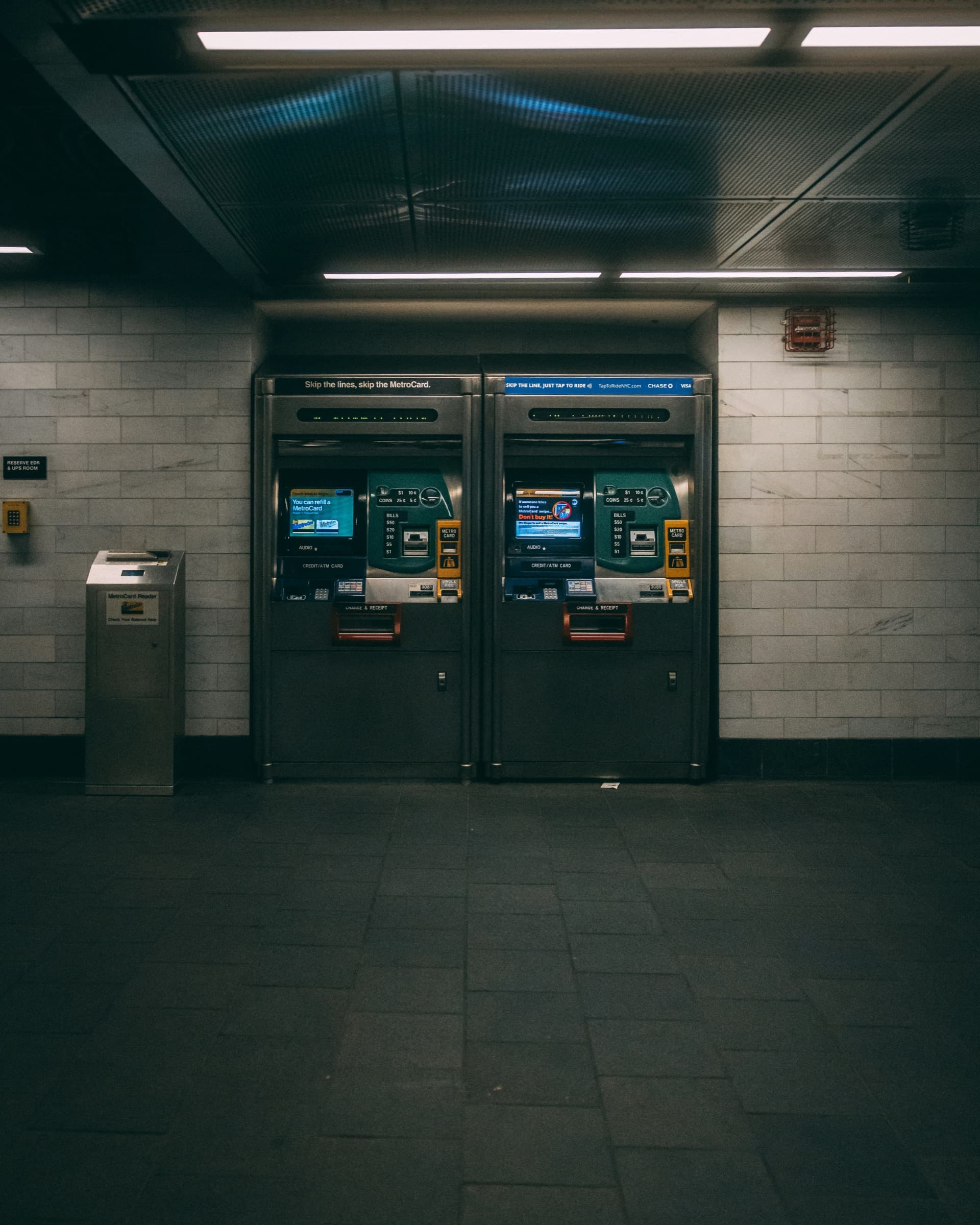 A row of cash machines along a tiled station wall