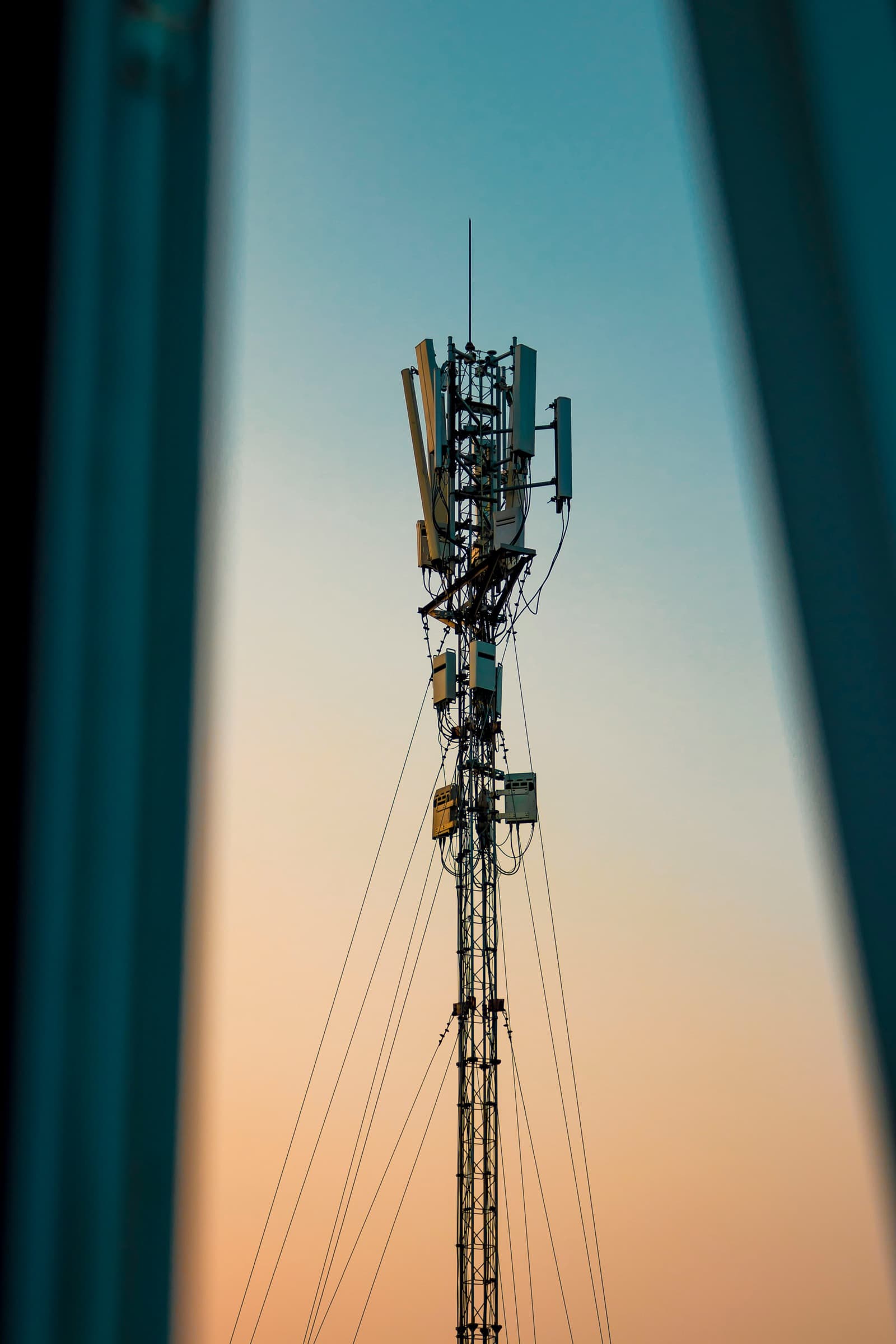 A telecoms mast against a pale open sky